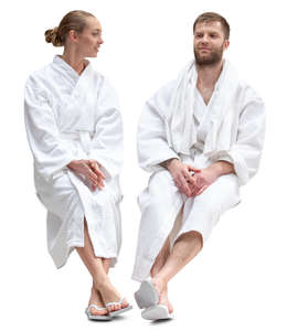 man and woman in bathrobes sitting in a spa and talking 
