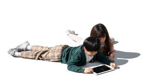 two cut out asian kids lying on the floor and looking at a tablet