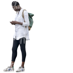 black woman in a striped white shirt standing and looking at her phone