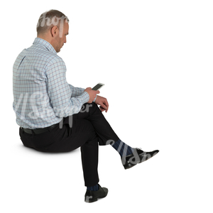 man sitting and looking at his phone