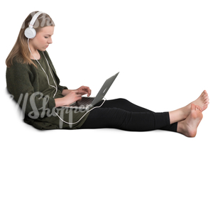 girl sitting on a couch and listening to music from her laptop