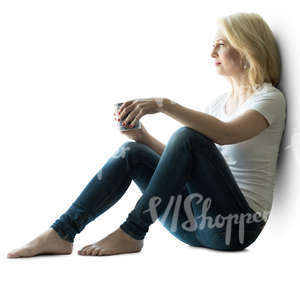 backlit woman sitting by the window and drinking coffee