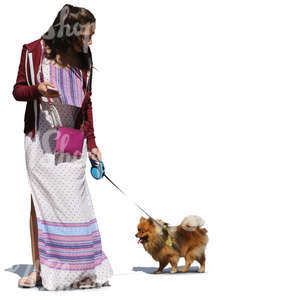 woman in a long summer dress walking a dog