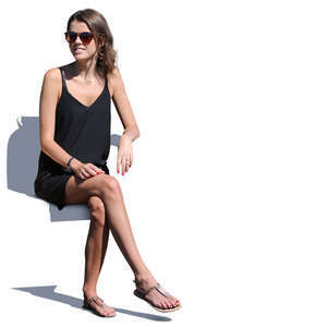 young woman in a black dress sitting in sunshine