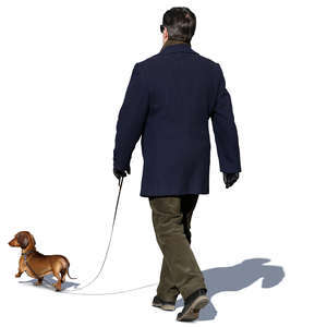 man in a dark blue coat walking a dog