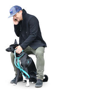 man sitting with his dog and talking on a phone
