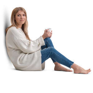 woman in a white pullover sitting and drinking coffee 