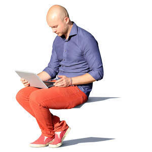 man sitting in sulight and looking at his laptop