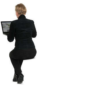 woman sitting behind the desk and working with her laptop