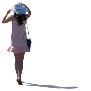 backlit woman in a pink summer dress walking