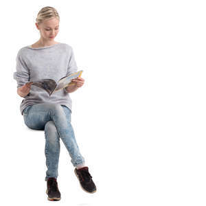 young woman sitting and reading a magazine