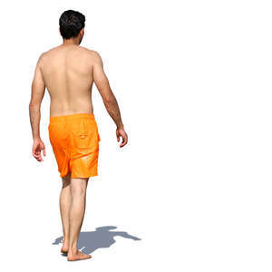 man in orange shorts walking barefoot on the beach