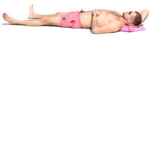 man in pink shorts lying on the beach