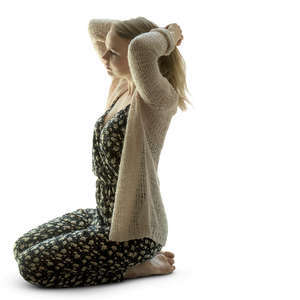backlit woman kneeling and fixing her hair