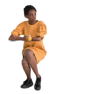 african woman sitting in a cafe and drinking juice