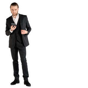 man in a suit standing and checking his phone