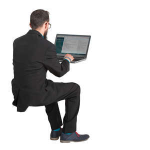 man in a suit sitting and working with laptop