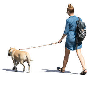 woman in a denim dress walking a dog