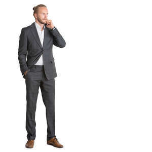young man in a suit standing and talking on a phone