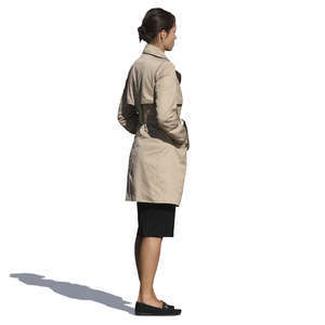 woman in a trenchcoat standing with her hands in her pockets