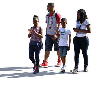 backlit african family of four walking down the street 