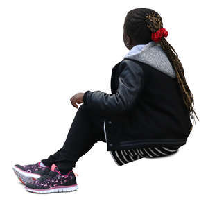 black girl with braided hair sitting on the sidewalk