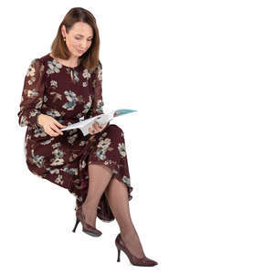 woman in a dress sitting and reading