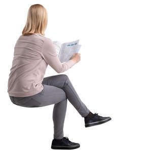 woman sitting at a table and reading a magazine