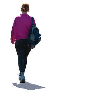 backlit woman with a backpack walking