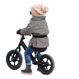 little girl riding a likeabike in autumn