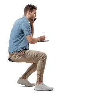 man sitting at a table and writing