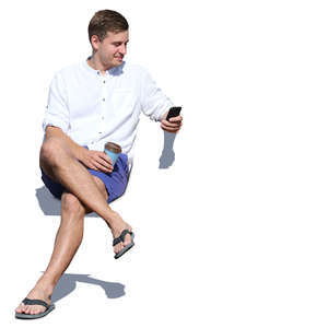 man sitting and looking at his phone and smiling