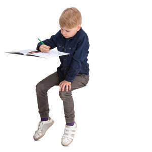boy sitting behind the desk and drawing