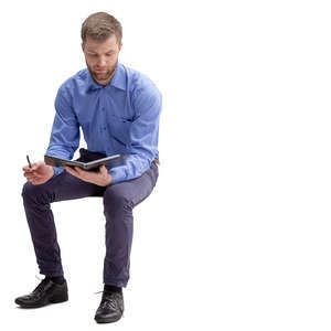 man in an office sitting and taking notes