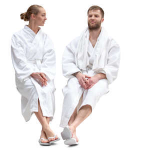 man and woman in bathrobes sitting in a spa and talking 
