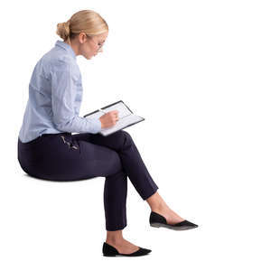woman in an office sitting and writing
