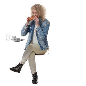woman sittng in a cafe and eating a sandwich