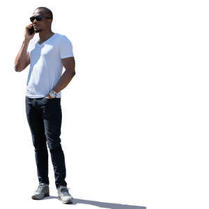 backlit man standing and talking on a phone