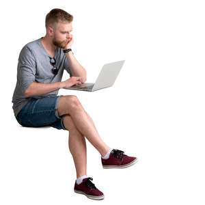 man with a laptop sitting behind the desk