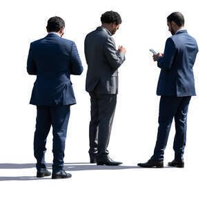 three businessmen standing and checking their phones