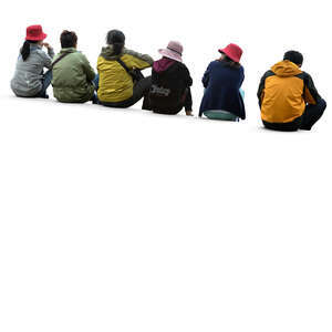 group of six people sitting on a sidewalk
