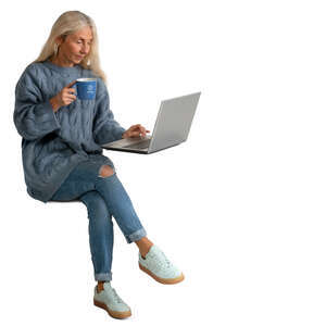 senior woman drinking coffee and looking at laptop