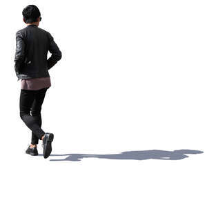 backlit asian man walking hands in his pockets