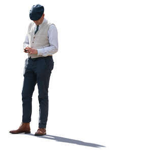 backlit man standing and checking his phone