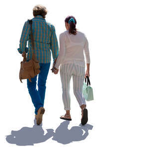 elderly backlit couple walking hand in hand