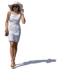 woman in a white summer dress and hat walking