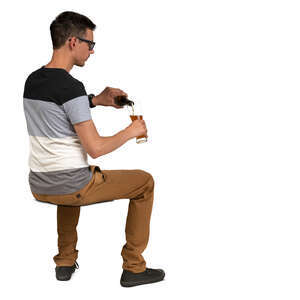 man sitting at a cafe table and pouring himself a drink