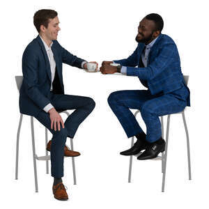 two men in suits sitting in a cafe and talking