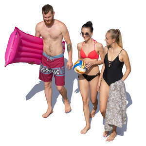 group of three young people walking at the beach seen from above