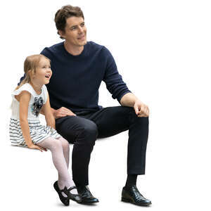 father and daughter sitting and looking happily at smth